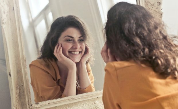 woman stares happily at her reflection
