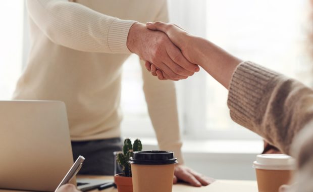 Image of two people shaking hands in an office